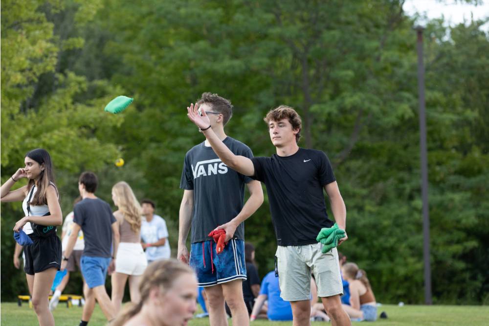 students playing cornhole and tossing green beanbag during Laker Kickoff